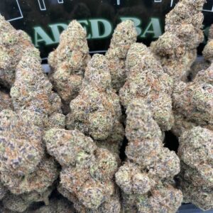 Lemon Razz cannabis strain with frosty trichomes and citrus-berry hues.