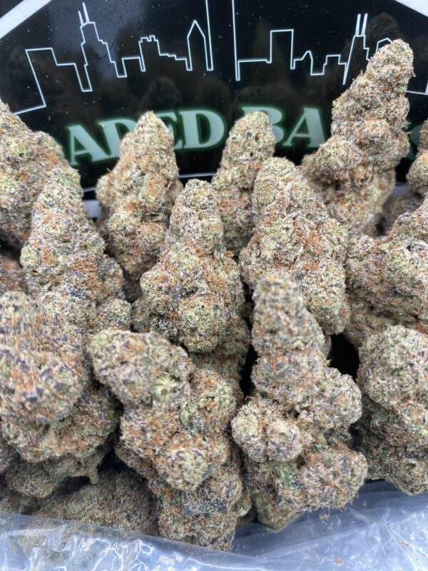 Lemon Razz cannabis strain with frosty trichomes and citrus-berry hues.
